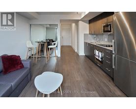 A modern kitchen with stainless steel appliances and a dining area with a table and chairs.