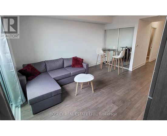 A living room with a grey couch and a white coffee table.