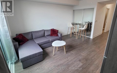 A living room with a grey couch and a white coffee table.