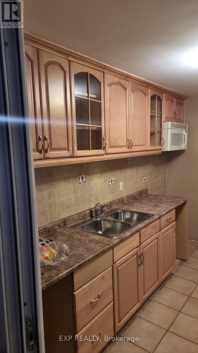 A kitchen with brown cabinets and a sink.