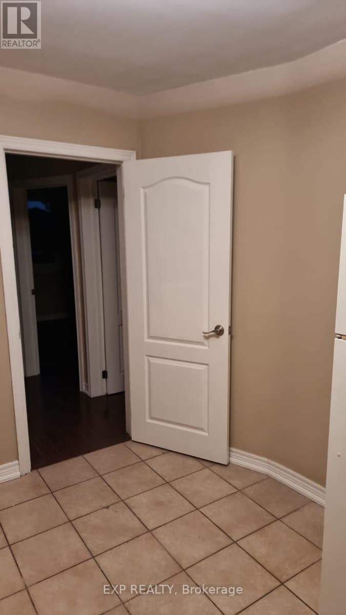 A white door is in a room with tiled flooring.