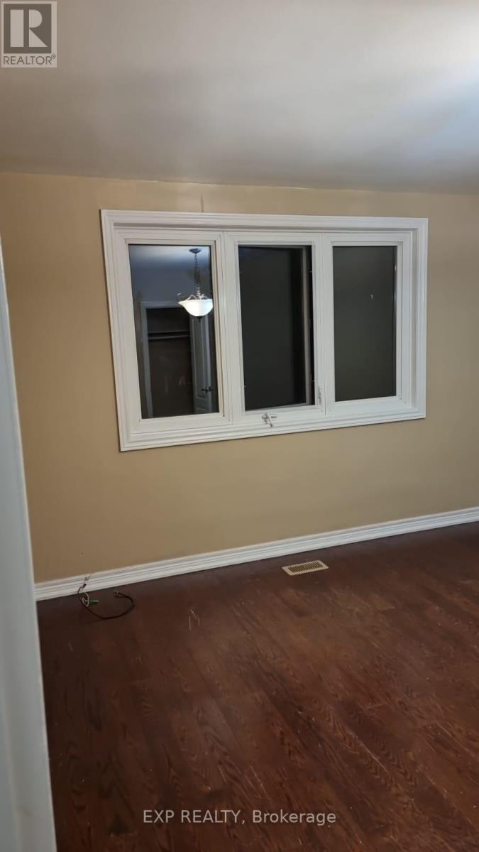 A room with a window and wooden flooring.
