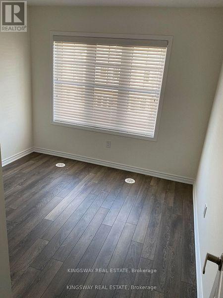 A room with a window and wooden flooring.