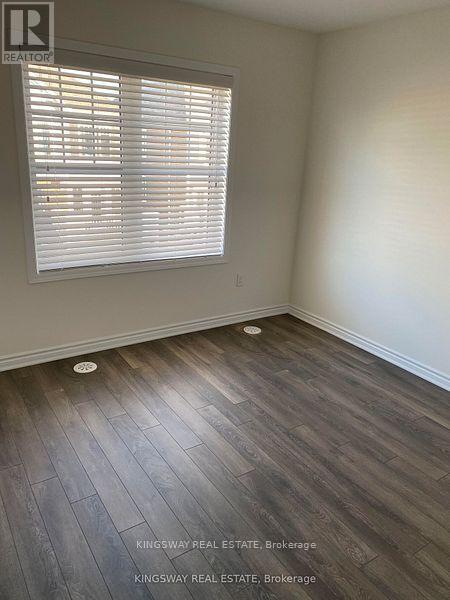 A room with a window and wooden flooring.