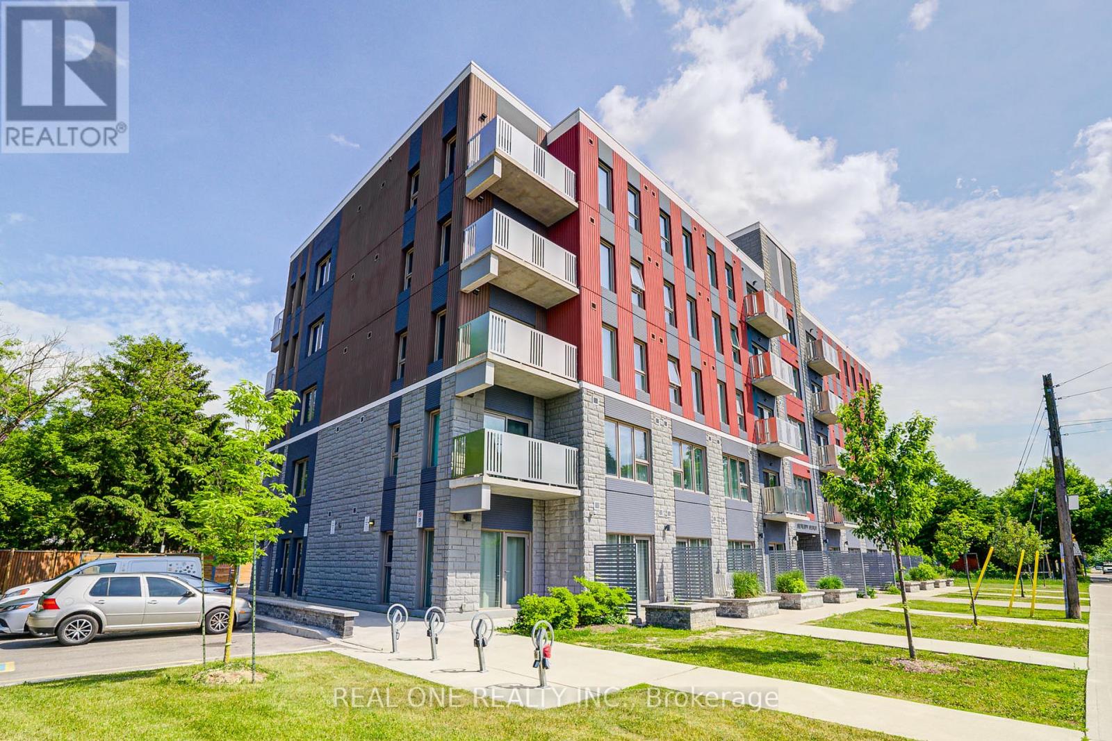 A multi-story apartment building with a car parked in front.