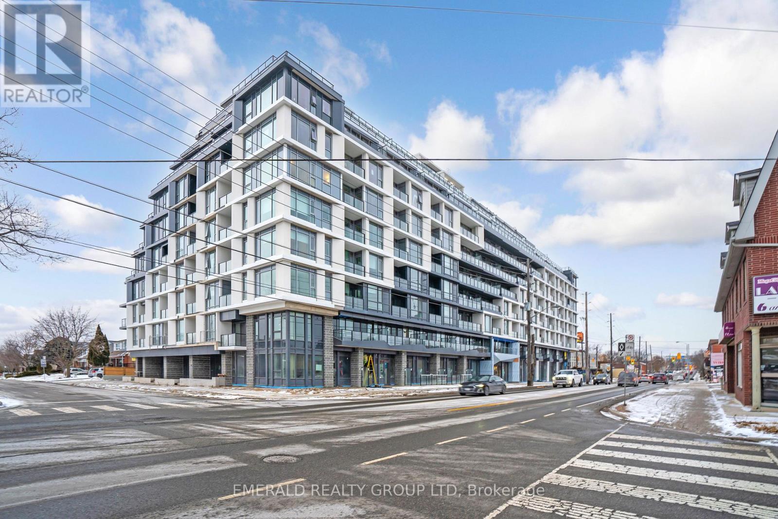 A modern multi-story building with glass windows and balconies is under construction.