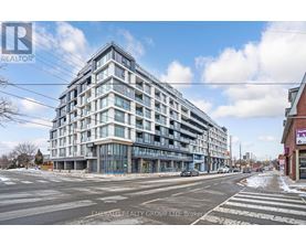 A modern multi-story building with glass windows and balconies is under construction.