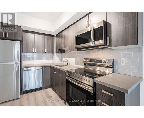 A modern kitchen with dark wood cabinets and stainless steel appliances.