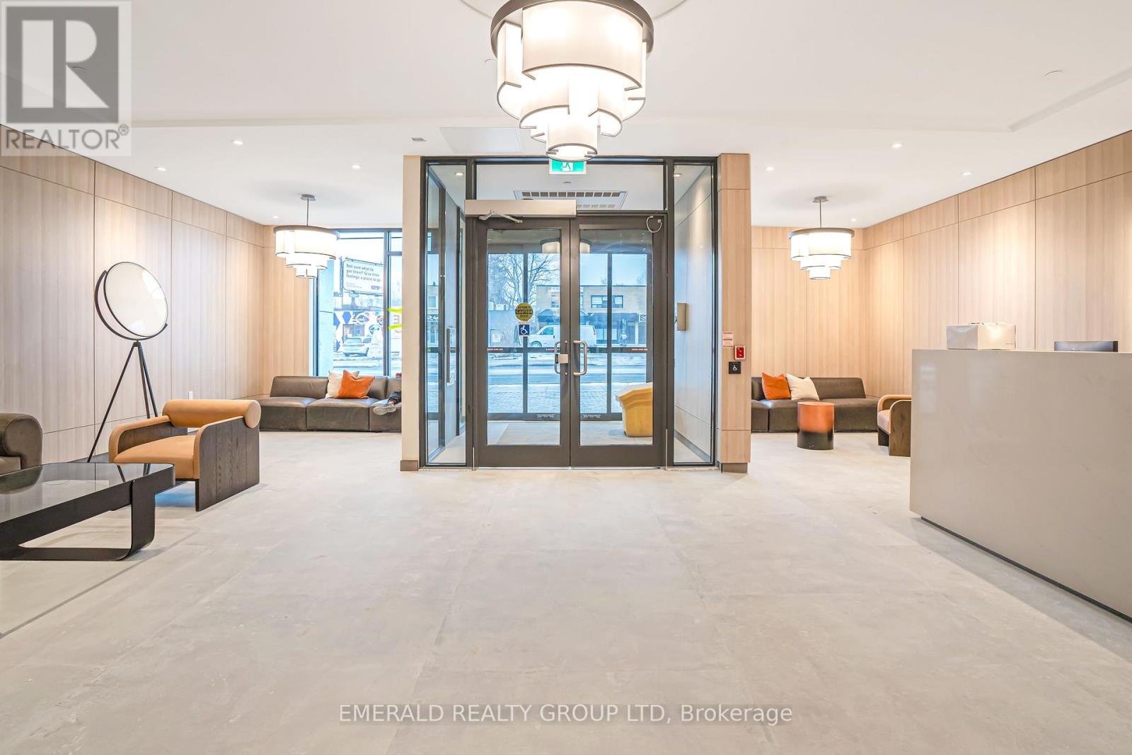 A modern office lobby with a glass door entrance and a reception desk.
