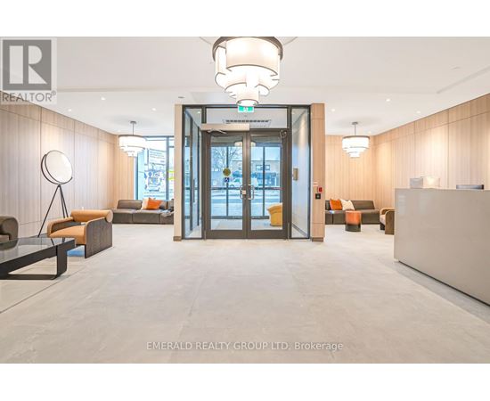 A modern office lobby with a glass door entrance and a reception desk.