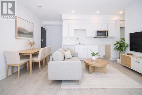 A modern living room with a dining table and a grey sofa.