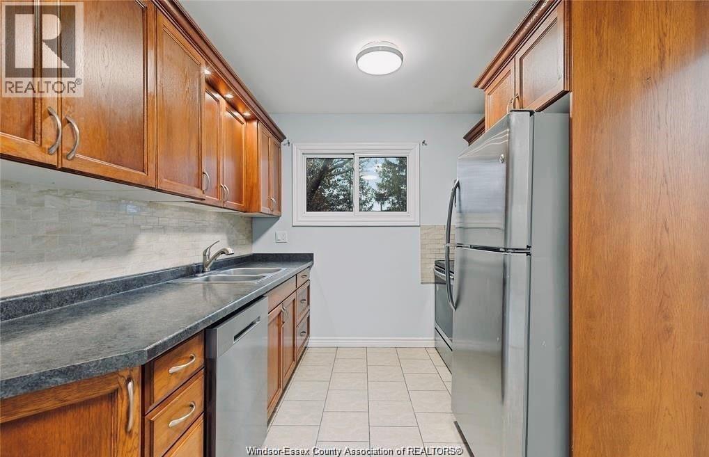 A kitchen with wooden cabinets and a refrigerator.
