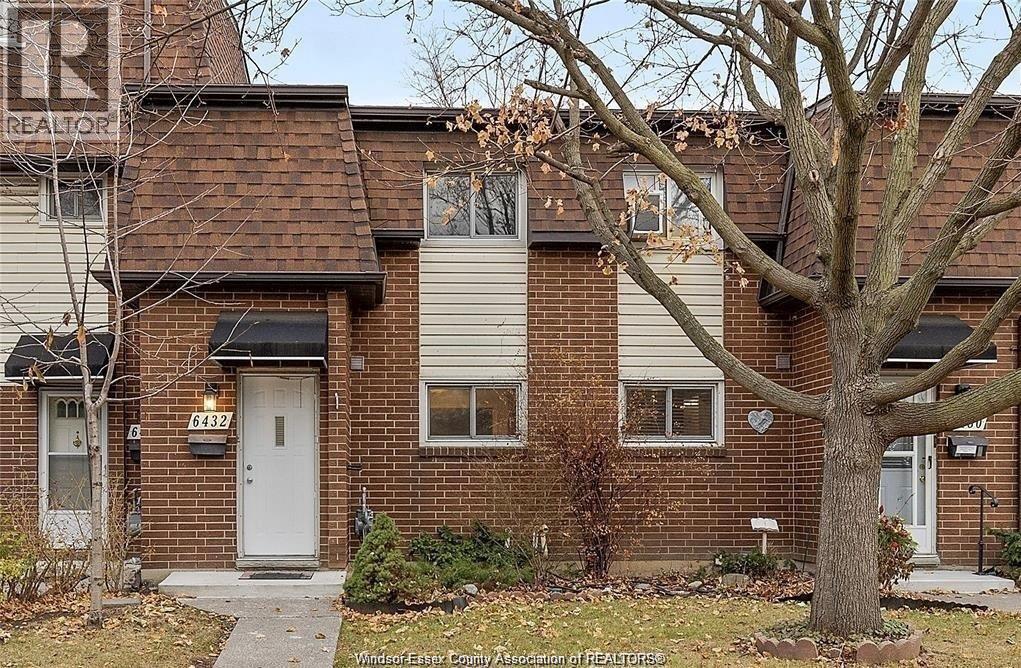 A house with a tree in front of it.