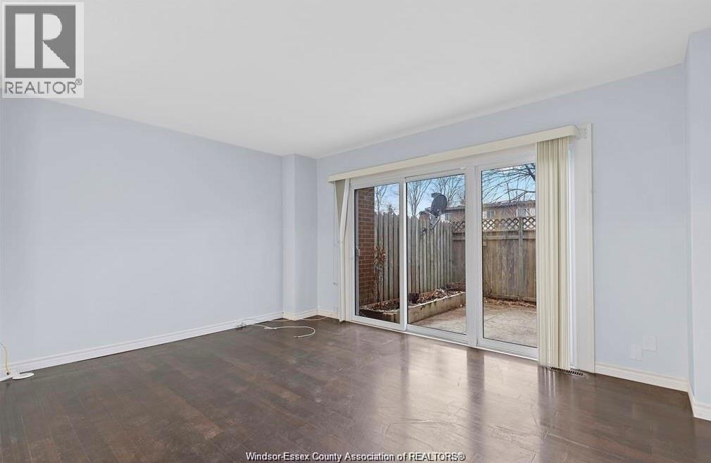 A room with a sliding glass door leading to a backyard.