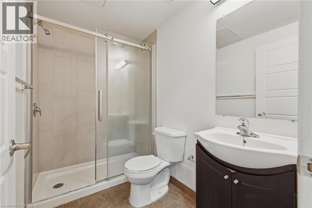 A bathroom with a toilet, sink, and shower.