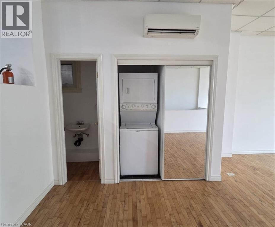 A white room with a washing machine in the doorway.