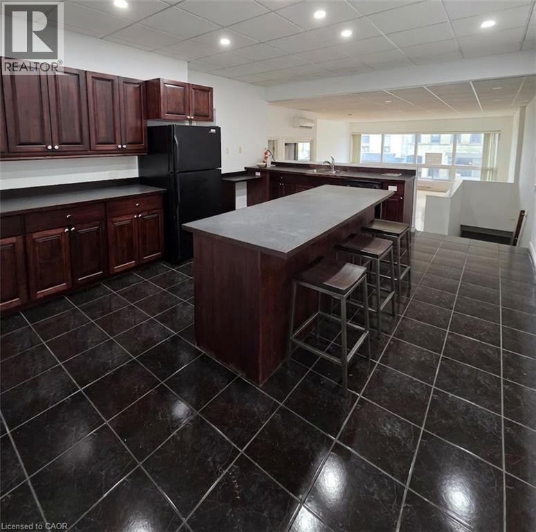 A kitchen with dark tiled floors and wooden cabinets.