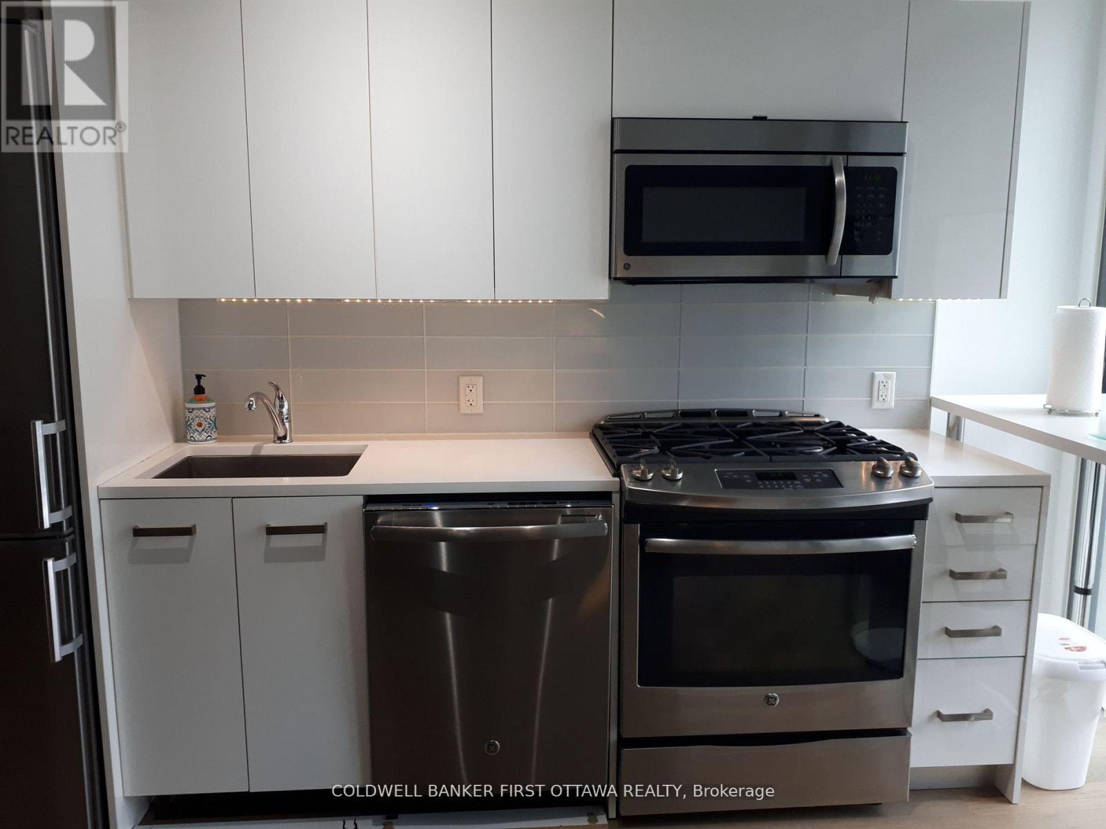 A modern kitchen with a stainless steel dishwasher and oven.