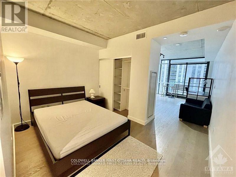 A bedroom with a large bed and a balcony.