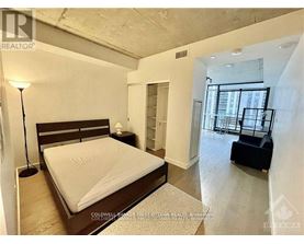 A bedroom with a large bed and a balcony.