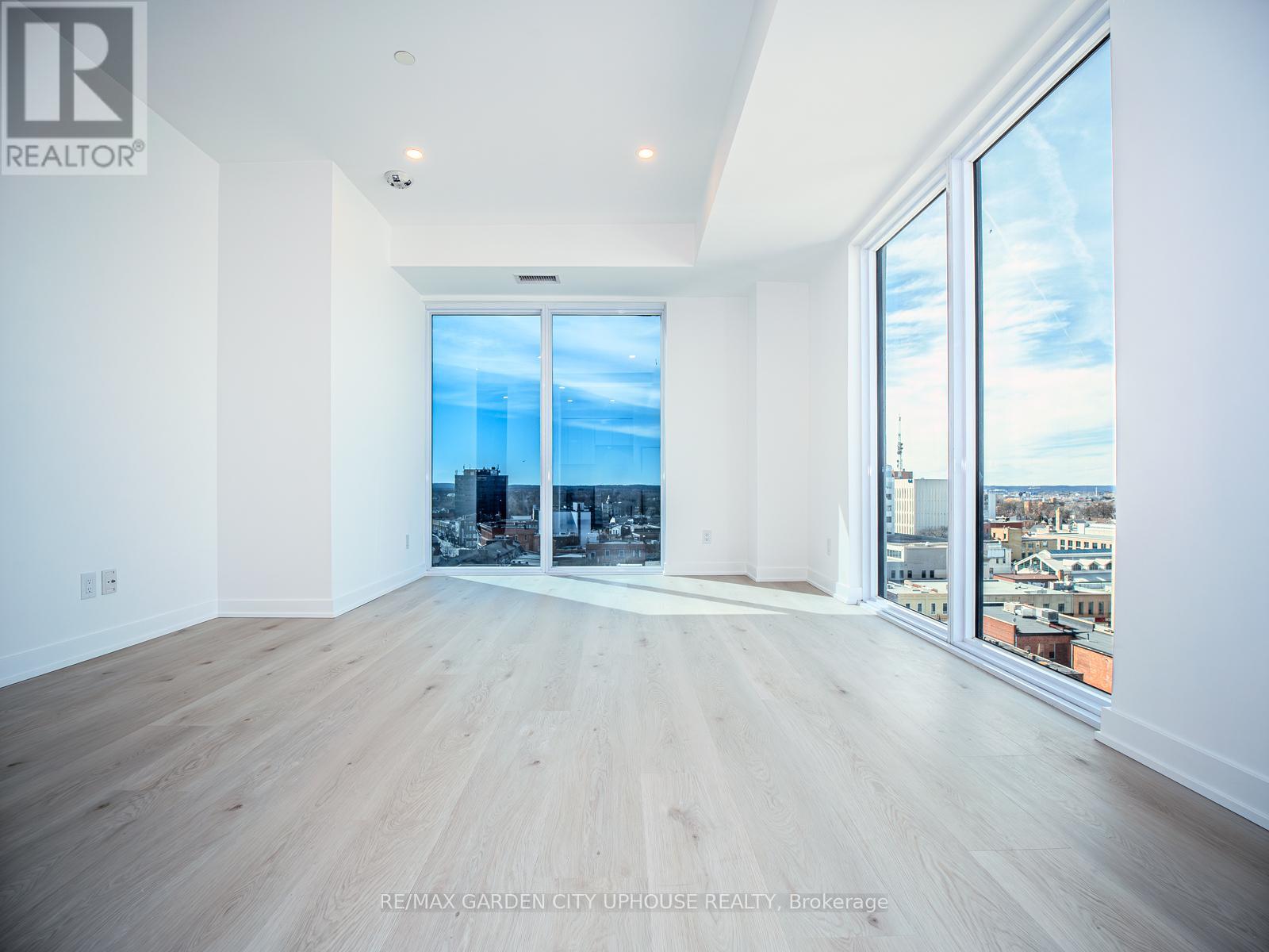 A spacious, empty room with a view of the city through large windows.