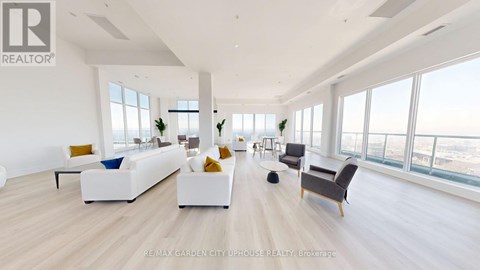 A spacious living room with white furniture and a view of the city.