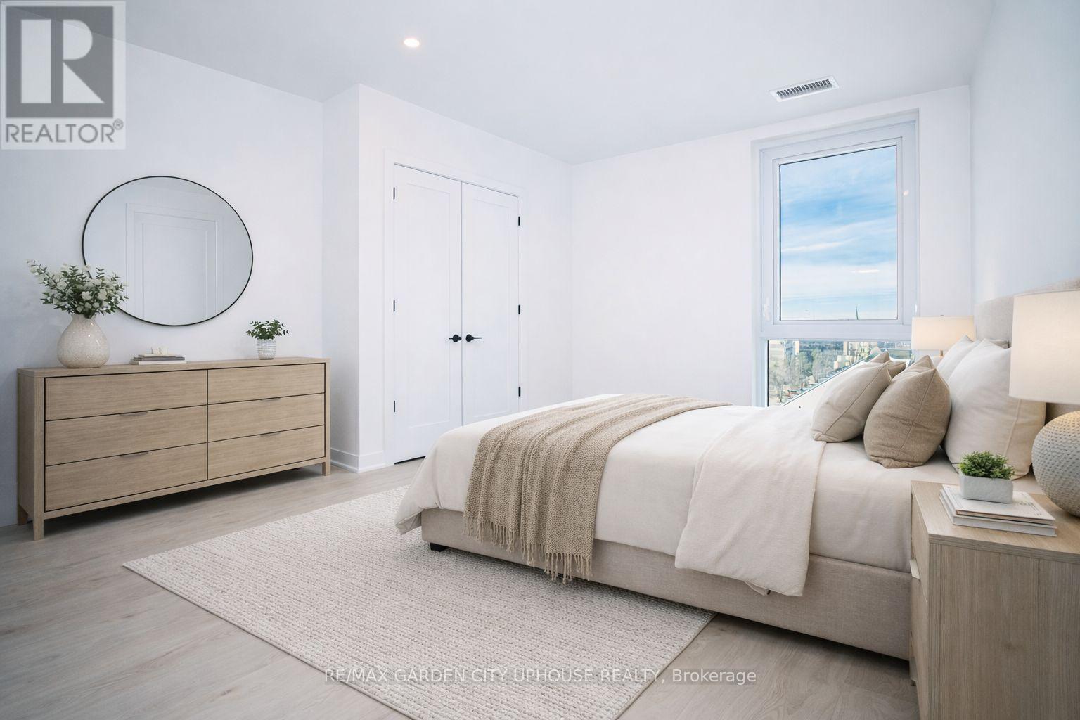 A bedroom with a large bed, a dresser, and a window with a view.