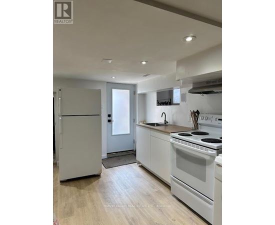 A kitchen with white appliances and wooden floors.
