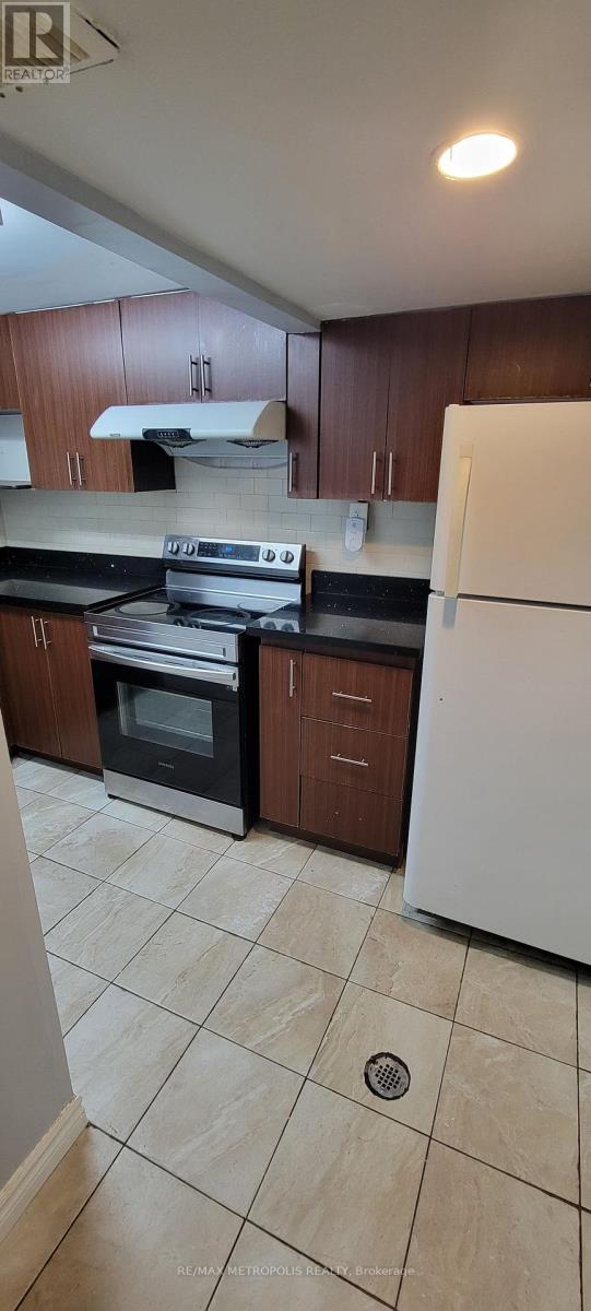 A kitchen with white appliances and brown cabinets.