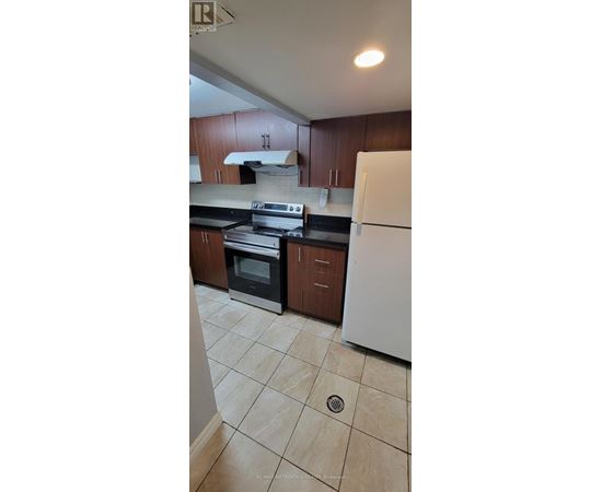 A kitchen with white appliances and brown cabinets.