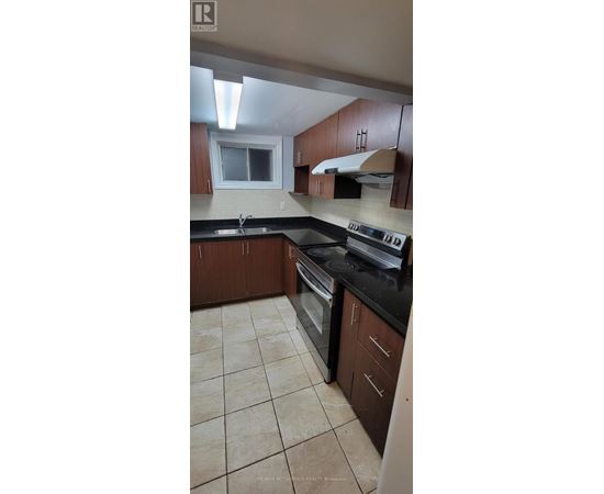 A kitchen with brown cabinets and black countertops.