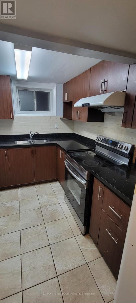 A kitchen with brown cabinets and black countertops.