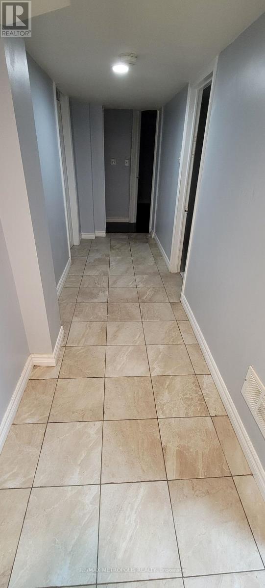 A hallway with tiled floors and a door at the end.