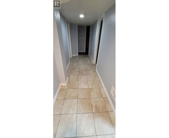 A hallway with tiled floors and a door at the end.