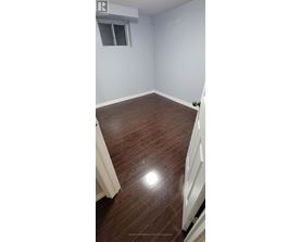 A room with wooden flooring and a window.