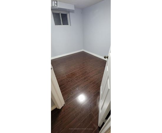 A room with wooden flooring and a window.