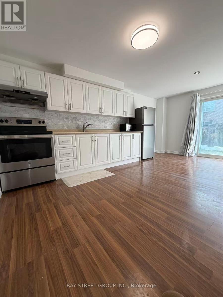 A kitchen with wooden floors and white cabinets.