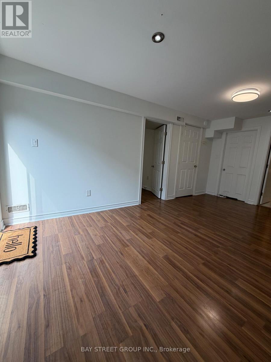 A room with wooden floors and white walls, with a mat on the floor.