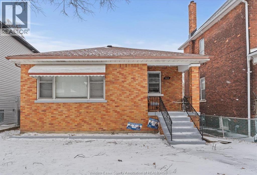 A house with a red brick exterior and a white window is for sale.