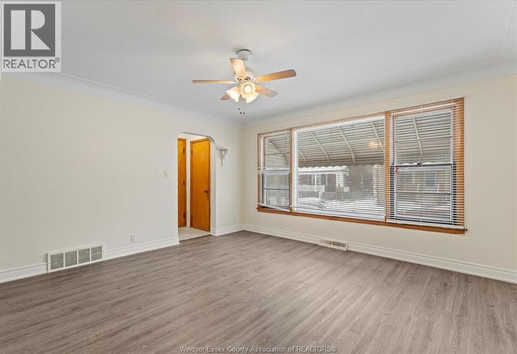 A room with a ceiling fan and a window with blinds.