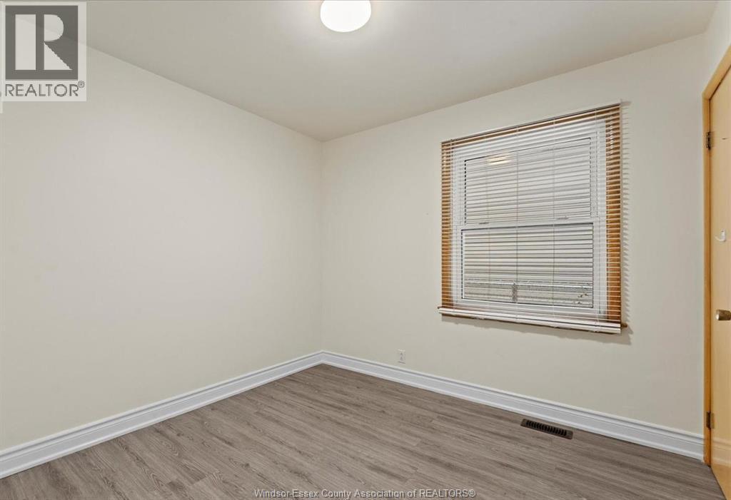 A room with a window and wooden flooring.