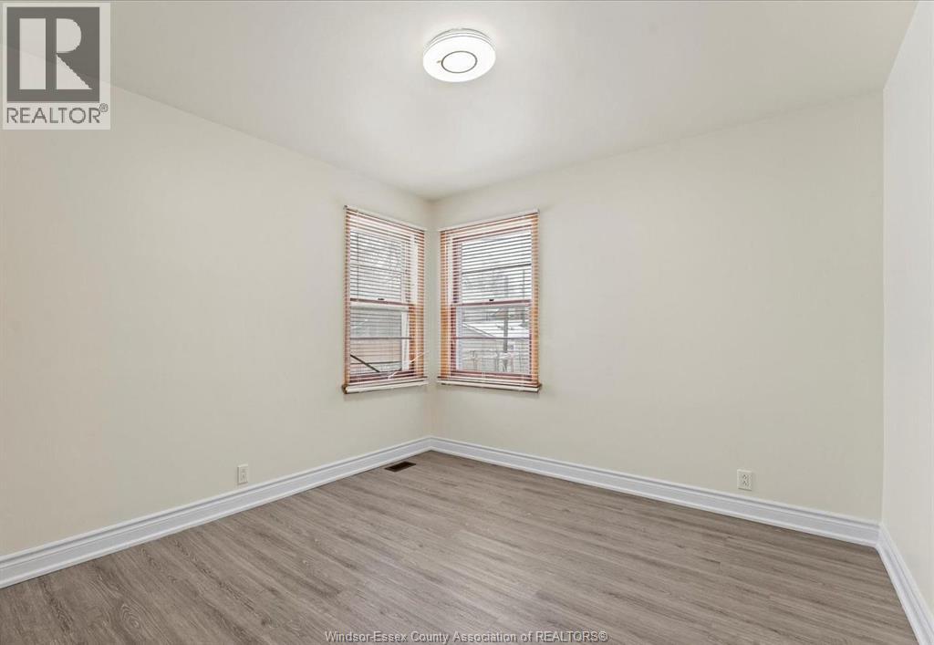 A room with a window and wooden flooring.