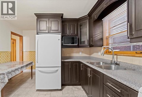 A kitchen with a white fridge and a microwave above it.