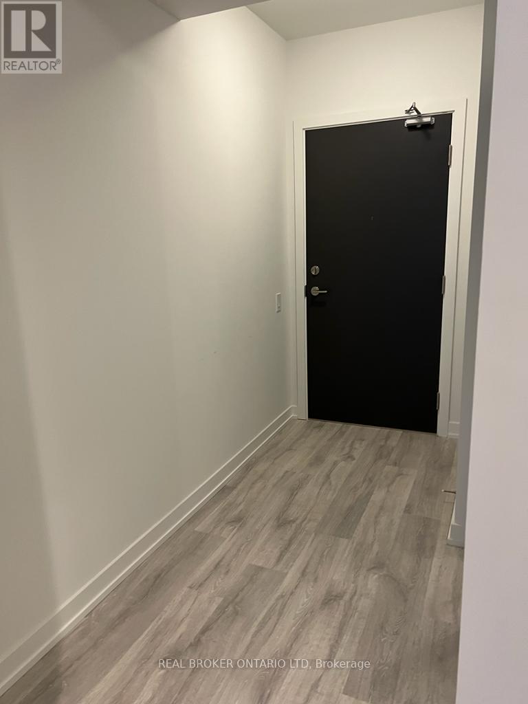 A black door is in a white hallway.