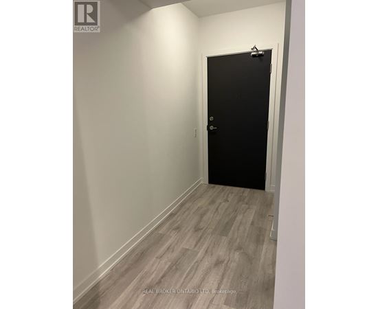 A black door is in a white hallway.