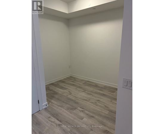 A room with a wooden floor and a white door.