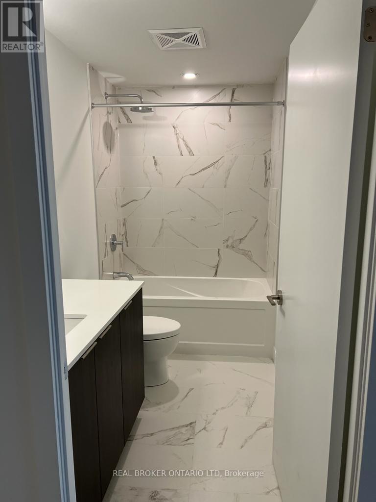 A bathroom with marble tiles and a walk-in shower.
