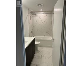 A bathroom with marble tiles and a walk-in shower.
