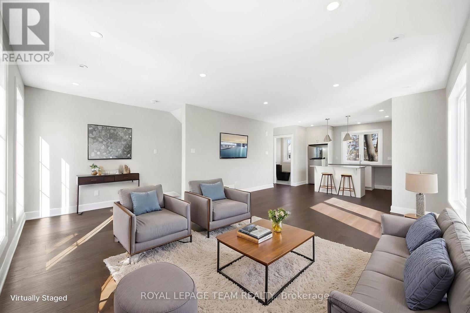 A living room with a grey couch, a coffee table, and a painting on the wall.