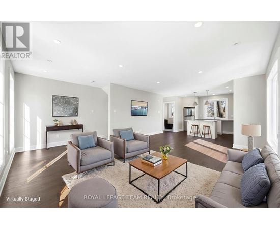 A living room with a grey couch, a coffee table, and a painting on the wall.